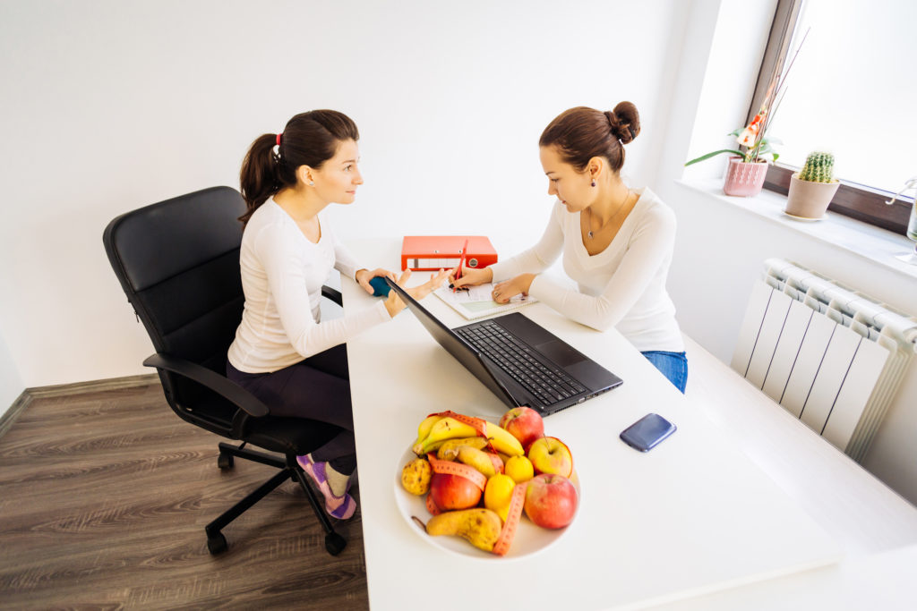 Woman visiting a nutritionist doctor for advice and treatment
