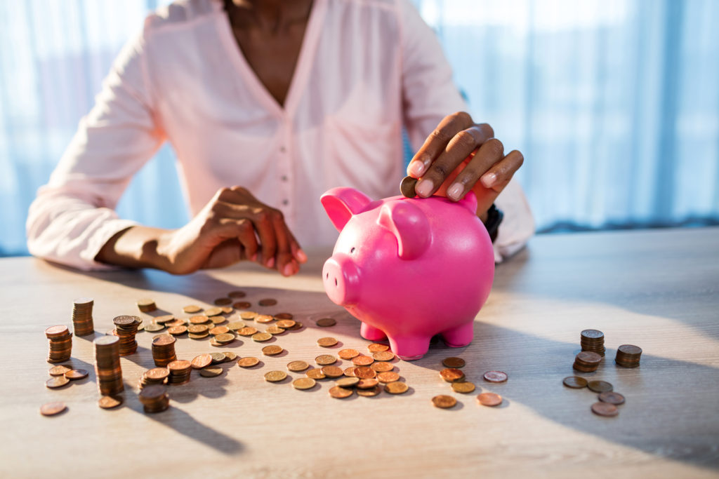 A parent saving pennies in a piggy bank to offset foster care costs.
